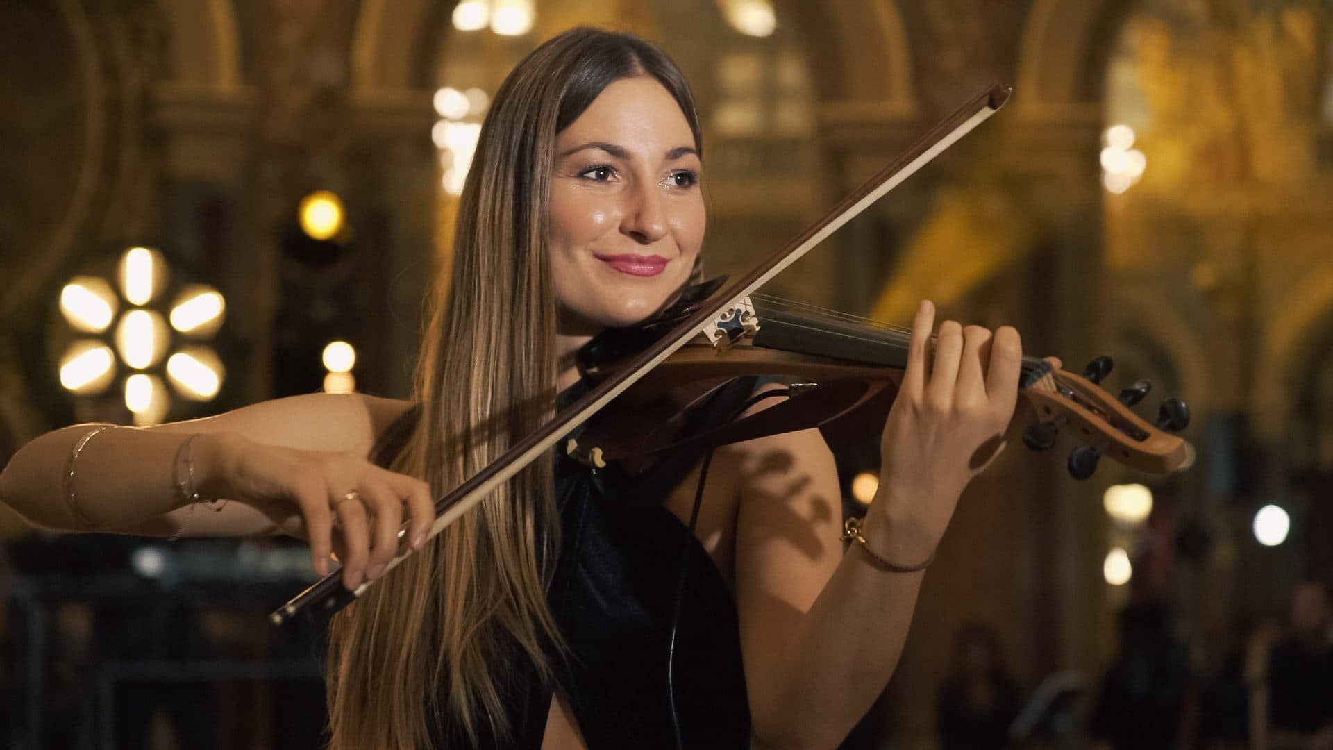 Violoniste jouant dans un salon d’apparat aux dorures et aux lustres allumés